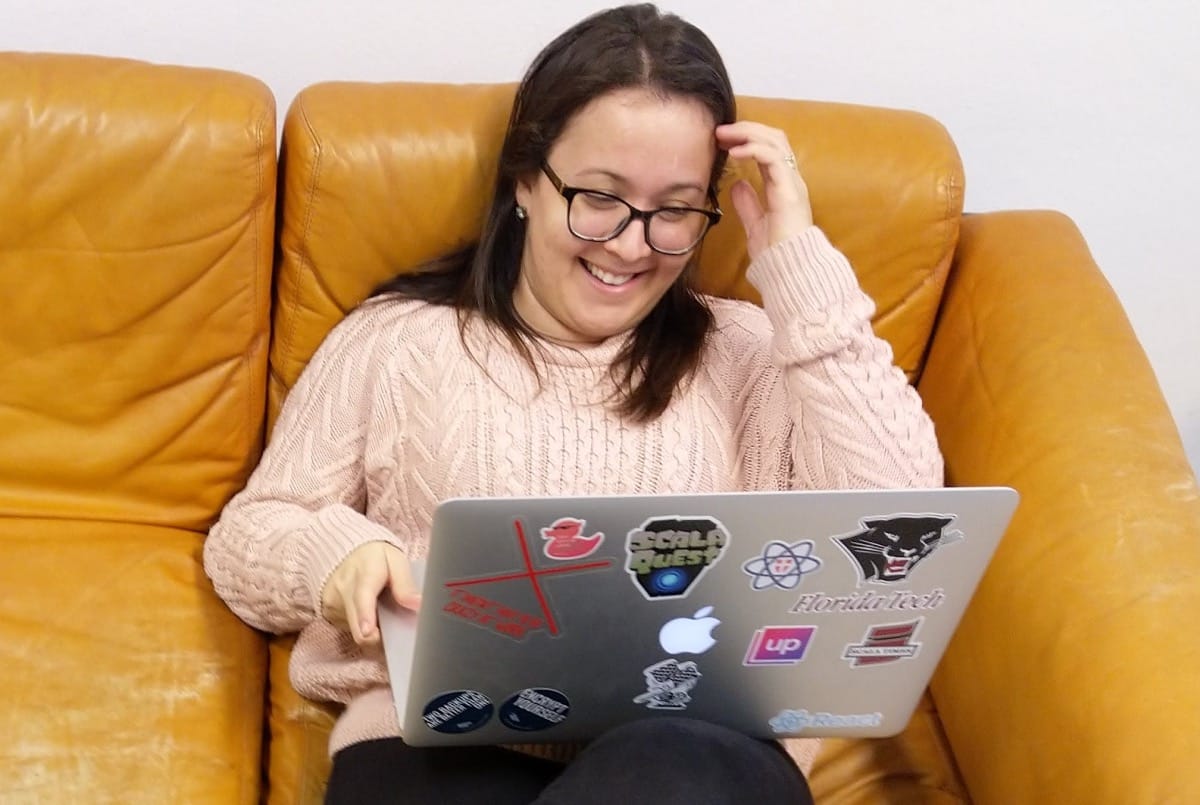 Rhaisa laughing on a sofa while coding