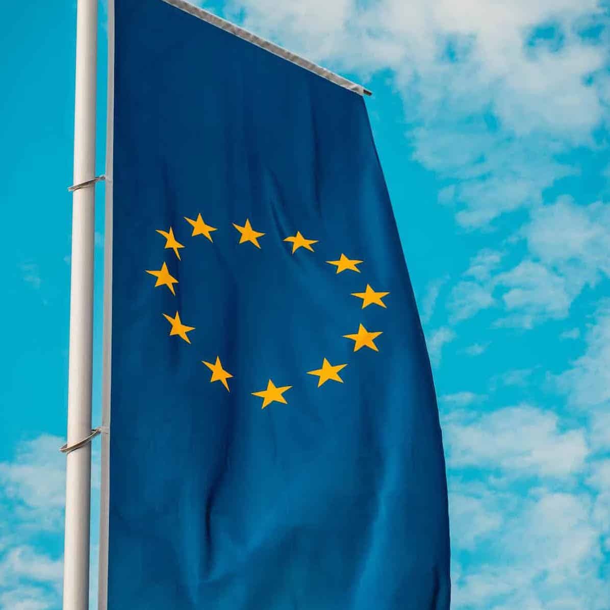 EU flag on a pole against blue sky