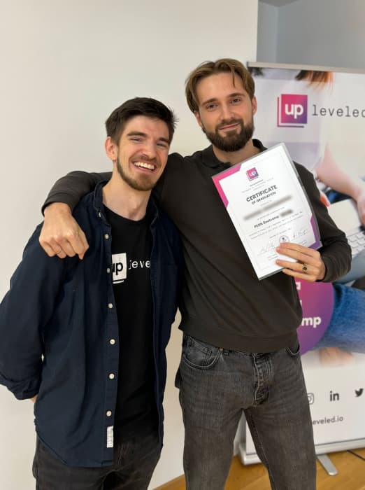 Male student proudly holding graduation certificate into camera, smiling and shaking hands with teacher